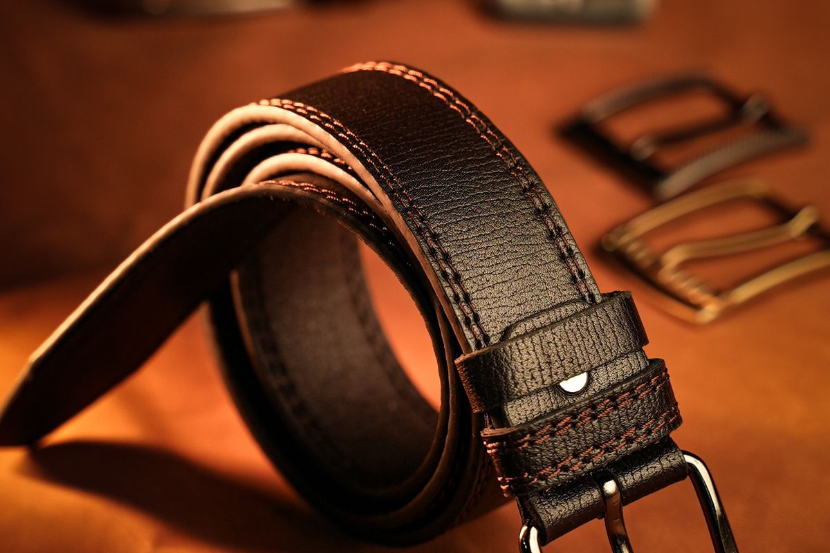 Men's leather belts with different buckles laid out together