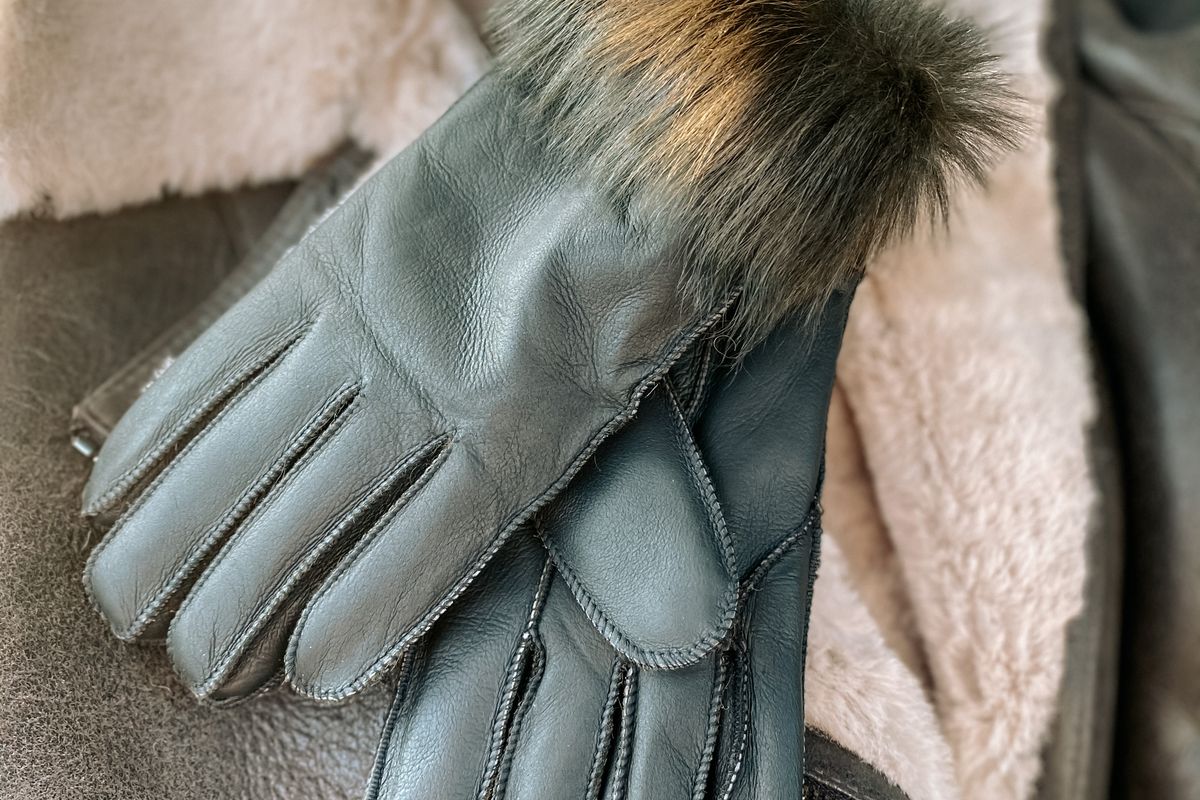 A pair of lined winter gloves with the lining pulled back to show the insulation layer inside