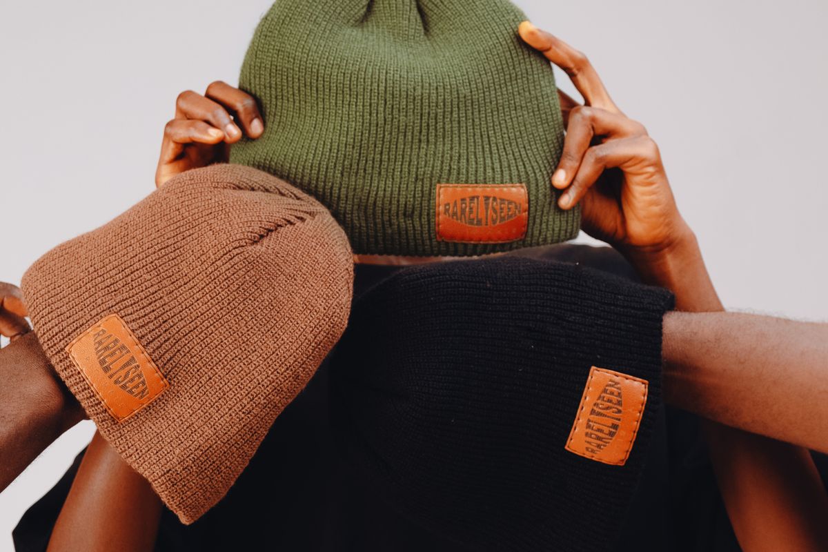 Knit beanies arranged on a plain surface in a minimalist display