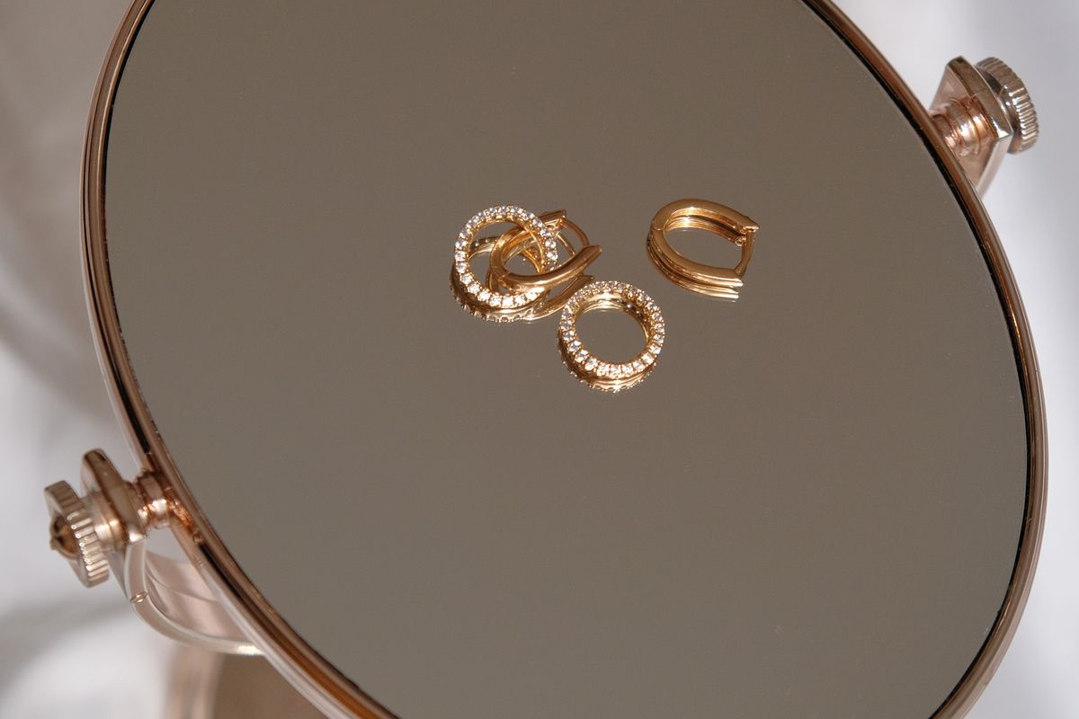 Gold rings resting on the mirror of a small jewellery stand