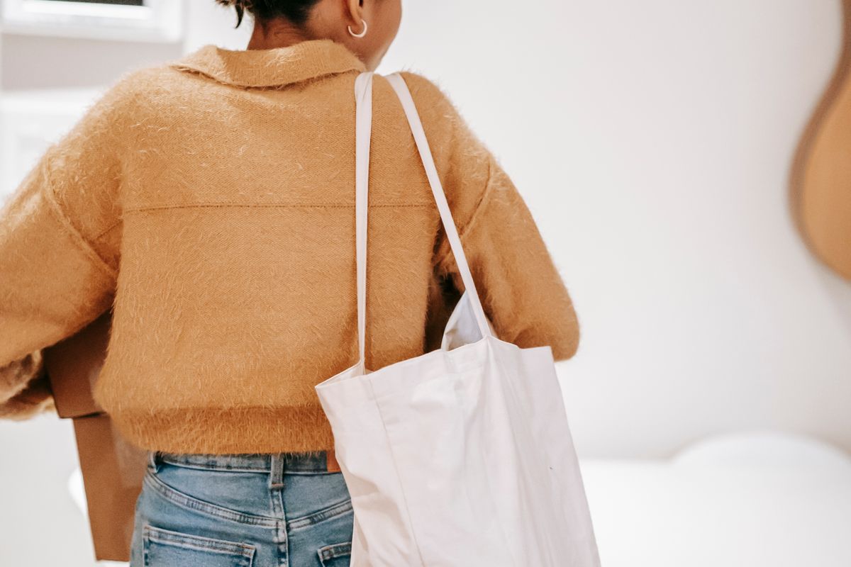 A woman packing goods into boxes at home, face out of frame