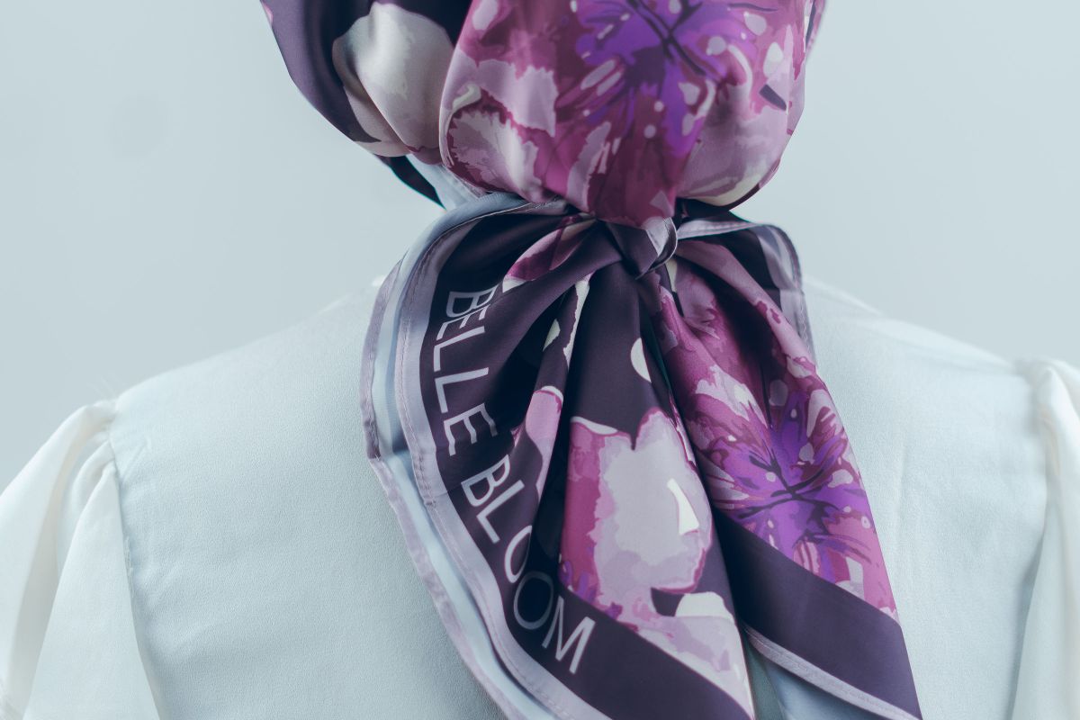 A floral silk scarf draped over a white outfit, seen from behind
