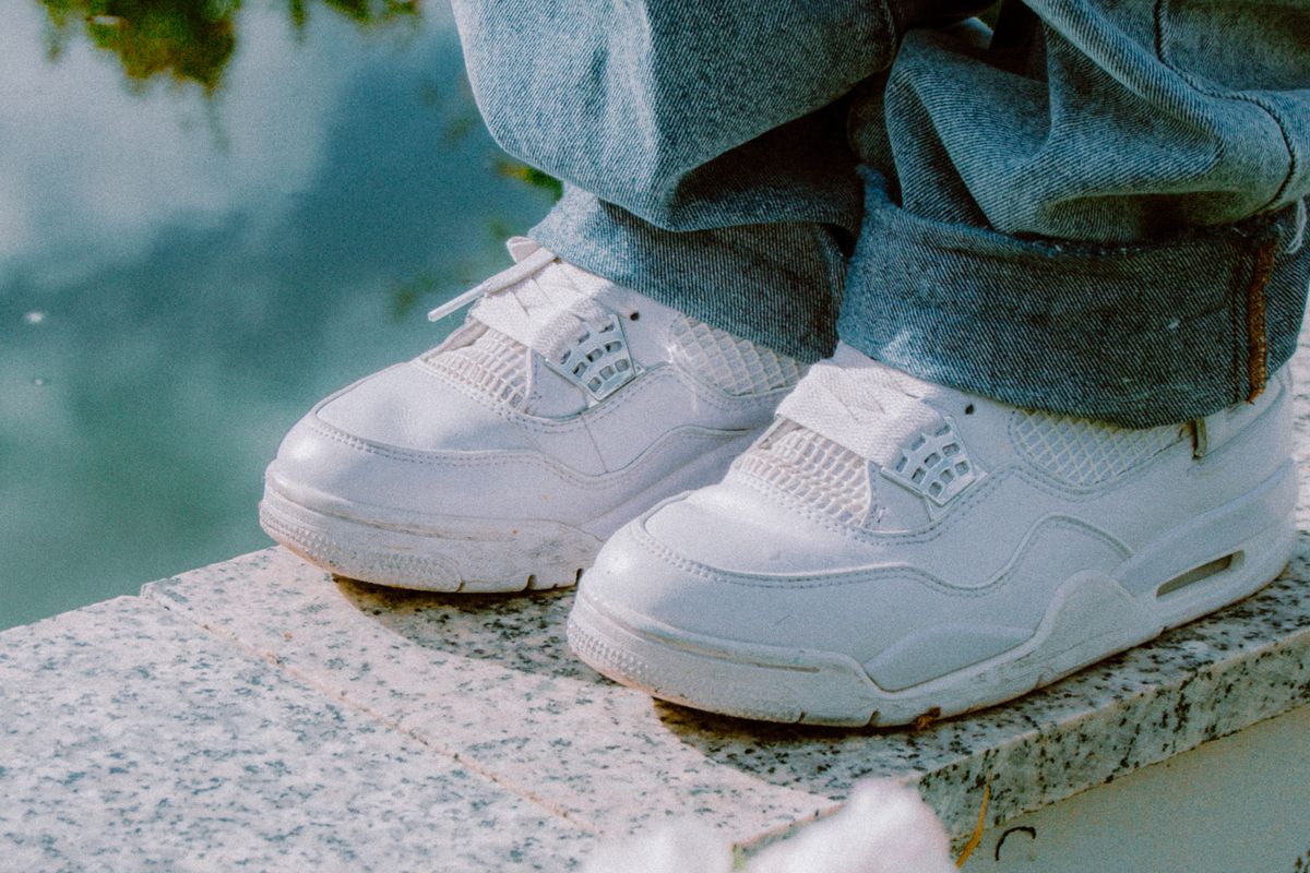 Close-up of white sneakers worn with wide-leg jeans